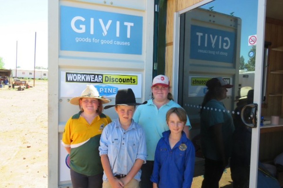 Four siblings in Mt Hope NSW standing in front of their brand new shipping container classroom donated by GIVIT